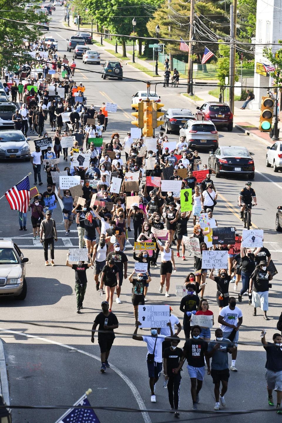 A crowd marches down Great Neck Road during