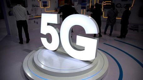 Visitors stand near a 5G logo at a