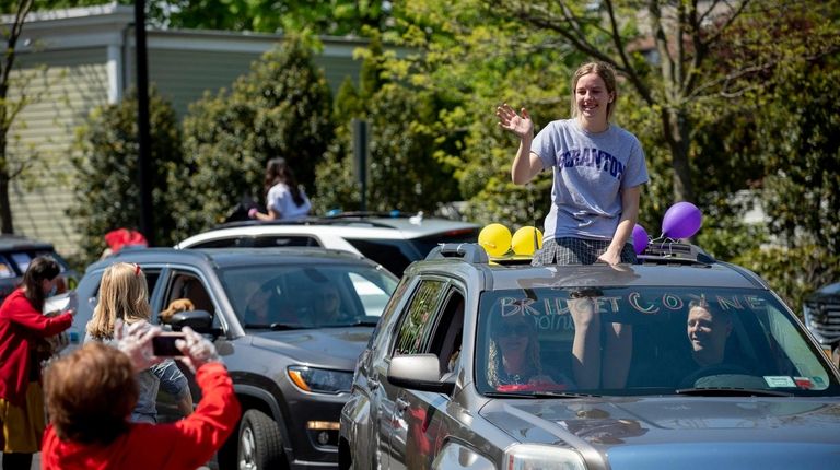 Sacred Heart Academy faculty members hand out caps