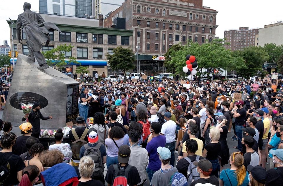 People attend a vigil in Harlem Friday, June