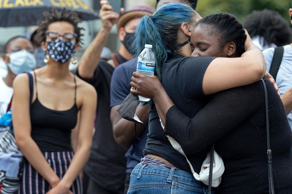 People embrace at a vigil in Harlem Friday,