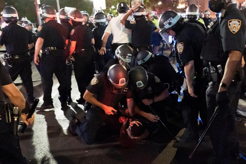 NYPD officers detain demonstrators who are protesting over