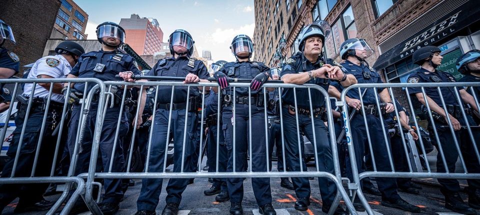 Protesters face the NYPD, while they rally through