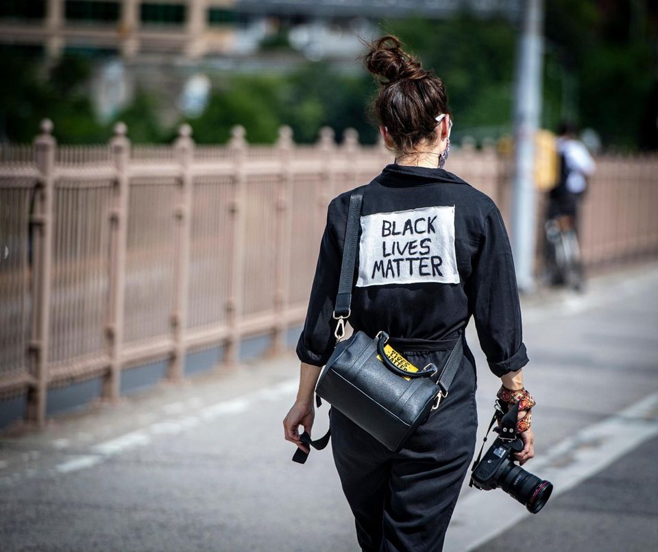 A woman walking with a camera voices her