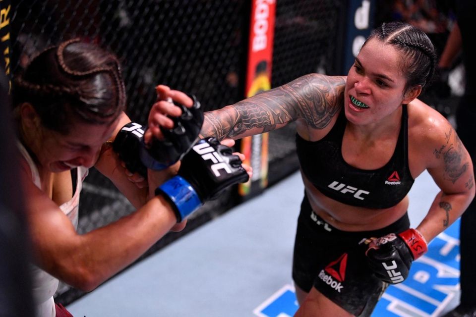 Amanda Nunes, right, punches Felicia Spencer in their