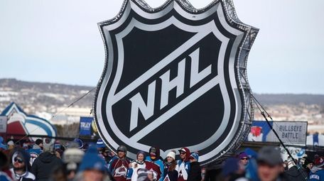 Fans pose below the NHL league logo at