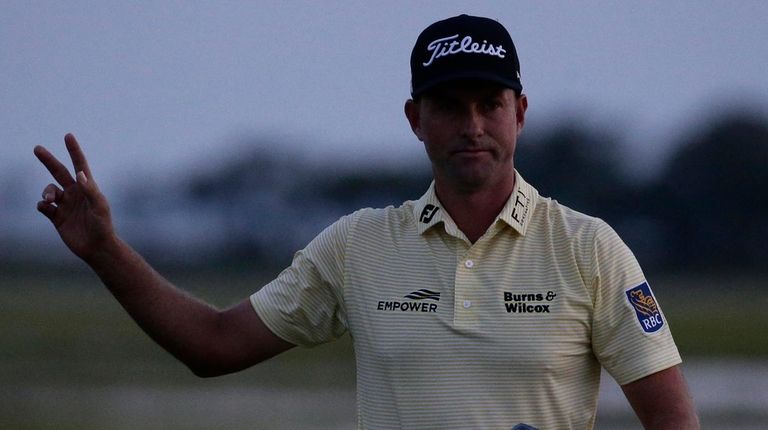 Webb Simpson waves as the sun disappears on