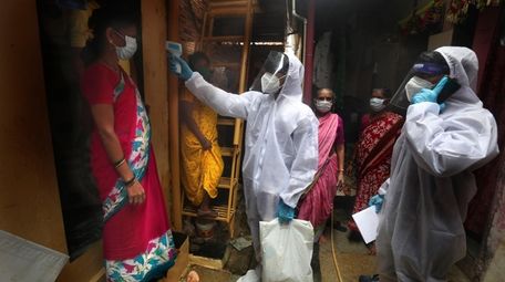A health worker checks the temperature of a