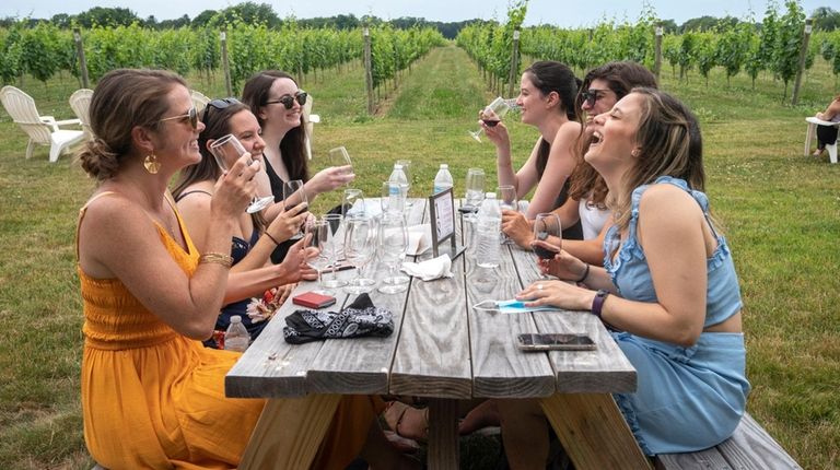 Friends taste wine at Bedell Cellars in Cutchogue
