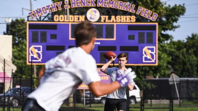 Sayville quarterback Jack Cheshire throws to a teammate