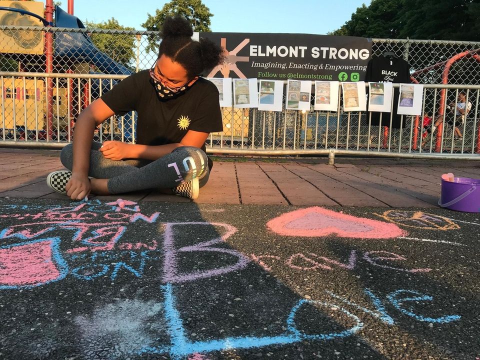 Atira Hall, 12, draws on the sidewalk at