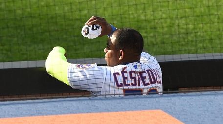 Mets' Yoenis Cespedes watches from the dugout against