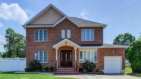 Priced at $1,049,888, this five-bedroom, three-bathroom brick Colonial