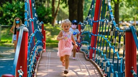 Lilly Wylaz, 3, runs across a suspension bridge