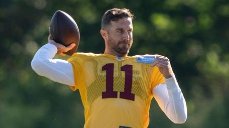 Washington quarterback Alex Smith throws, with quarterback Steven