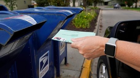 A person drops into a mail box applications