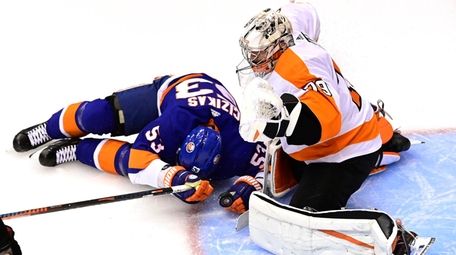 Islanders center Casey Cizikas slides into Flyers goaltender