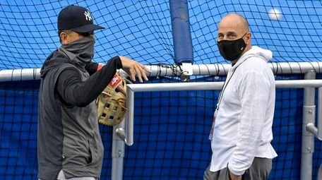 Yankees manager Aaron Boone, left, talks with general