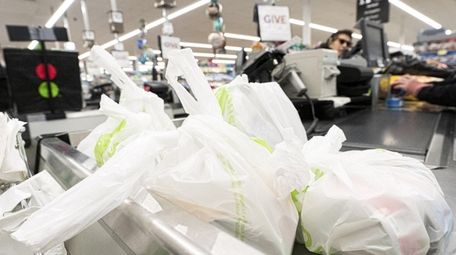 A customer's groceries are held in plastic bags