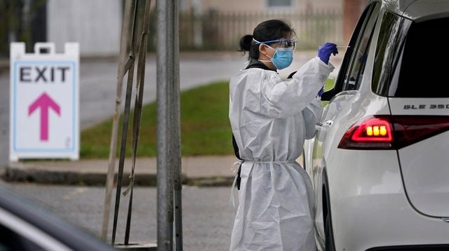 Medical personnel prepare to administer a COVID-19 swab