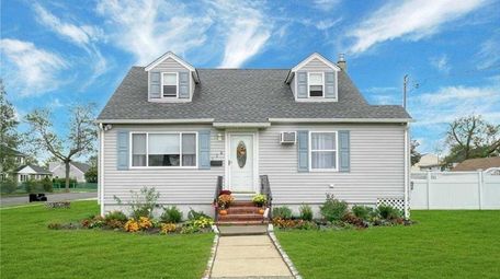 The house sits on a grassy yard on