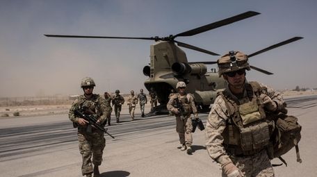 U.S. service members walk off a helicopter on