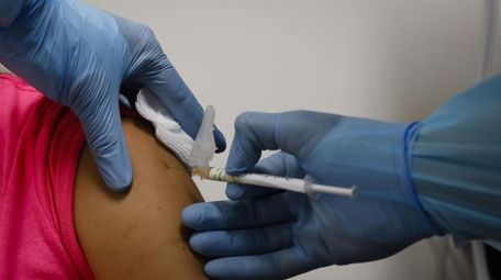A health worker injects a woman during clinical