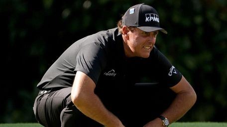 Phil Mickelson lines up a putt on the