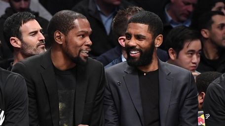 Kyrie Irving, right, chats with teammate Kevin Durant