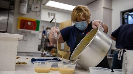 Friend's Kitchen volunteer Valerie Scherer fills individual gravy
