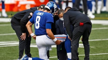 Trainers check Giants quarterback Daniel Jones after an