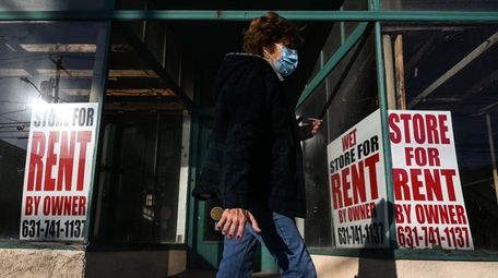 A woman walks past an empty store on