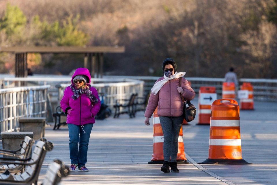 Bundled up for the cold, two women walk
