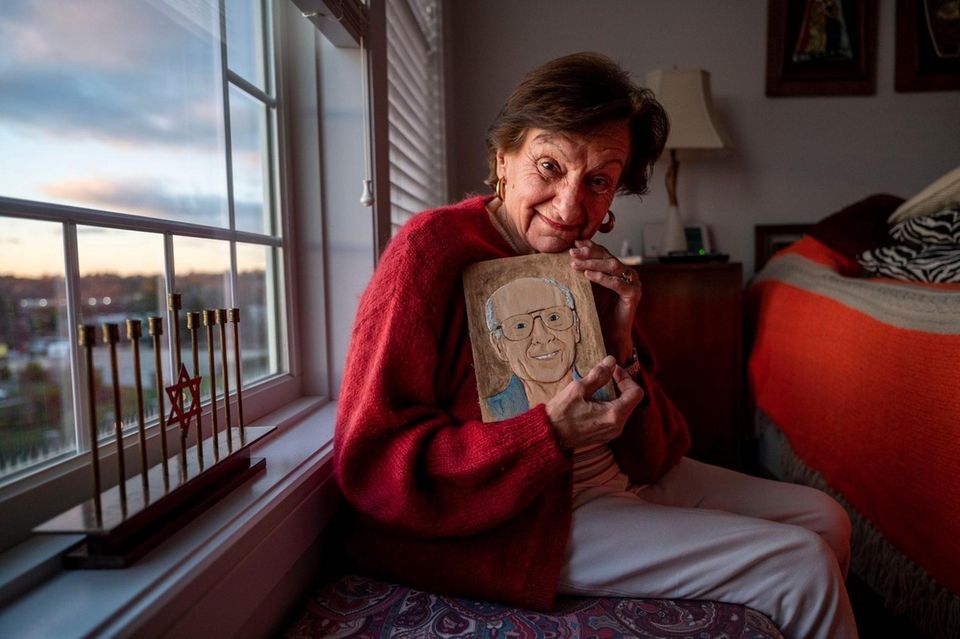Marsha Elowsky poses with a carved wooden potrait