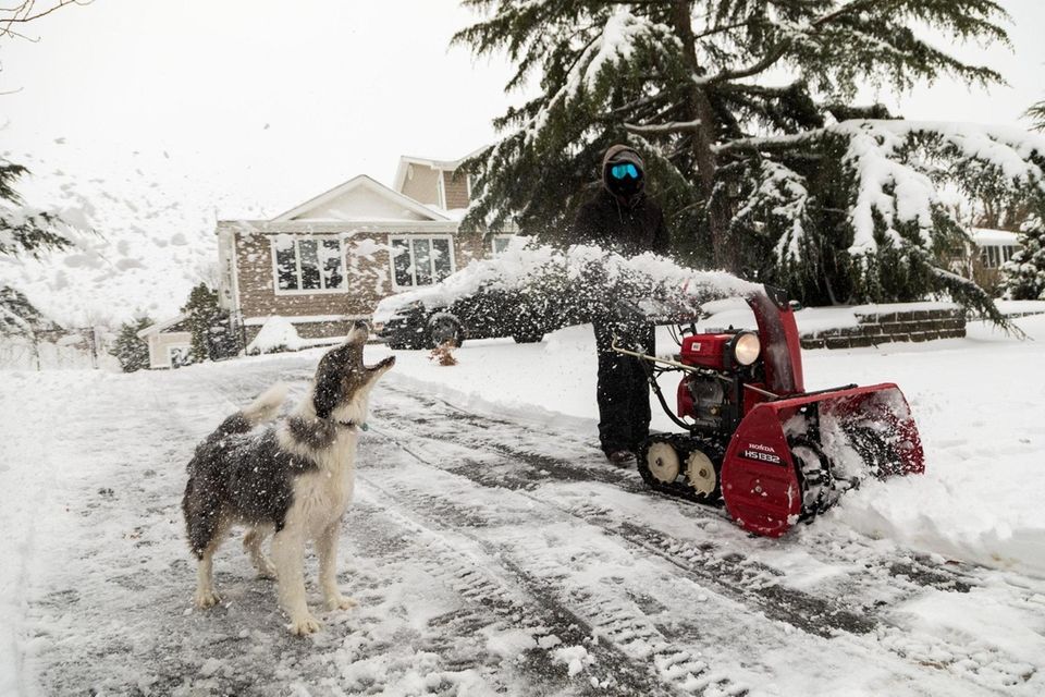 Paul Zucconi uses a snow blower to clear