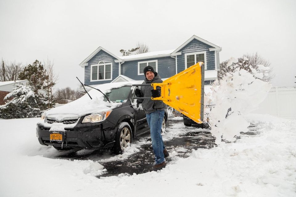 Aaron Perretta shovels the driveway of his home