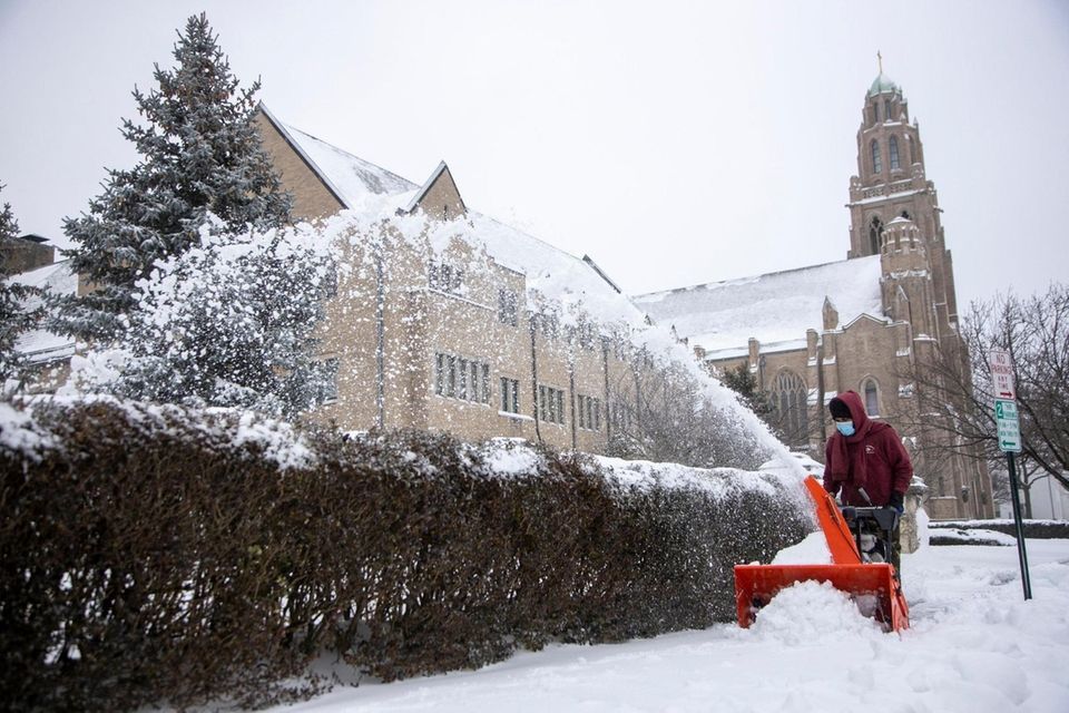 Miguel Angel works on clearing the sidewalk outside