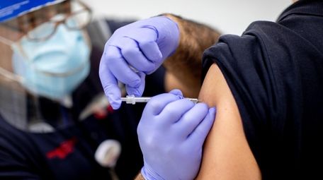 EMT-paramedic Ian Mauro administers the vaccine at Stony