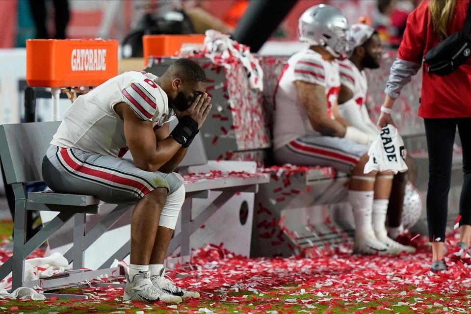 Ohio State players sit on the bench after