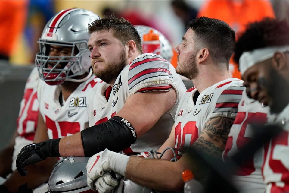 Ohio State players sit on the bench after