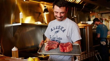 Chef-owner Alexis Trolf readies two dry-aged ribeye steaks