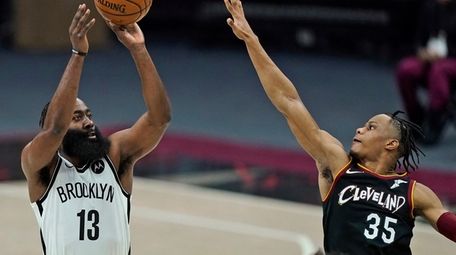 The Nets' James Harden shoots over the Cavaliers'