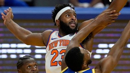 Knicks center Mitchell Robinson defends against a shot
