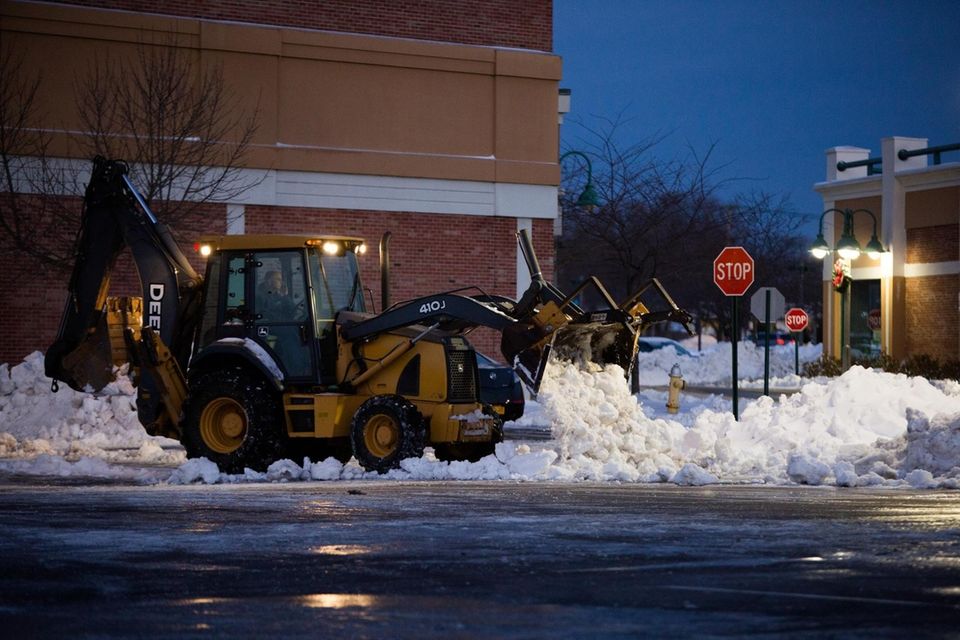 A plow moves snow at the Mayfair Shopping