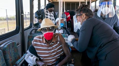 A senior receives a COVID-19 vaccine from a