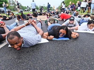 Protestors chant on the ground while walking down