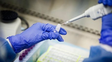 A laboratory technician prepares COVID-19 patient samples for
