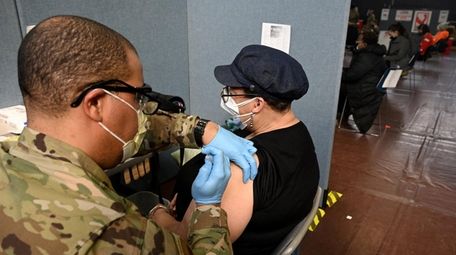A Brooklyn resident receives the COVID-19 vaccine at