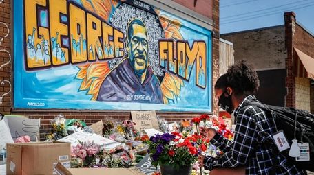 Malaysia Hammond, 19, places flowers at a memorial