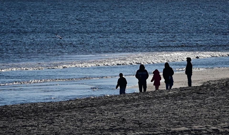 People walk along the beach at Robert Moses